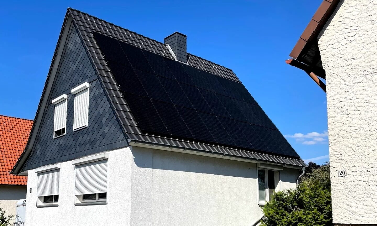 Wohnhaus mit schwarzen Solarmodulen auf dem Steildach